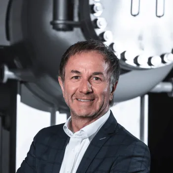 Porträt von Markus Widner, Geschäftsführer von APL Wärmetauscher, vor technischer Industrieanlage mit Wärmetauscher im Hintergrund.